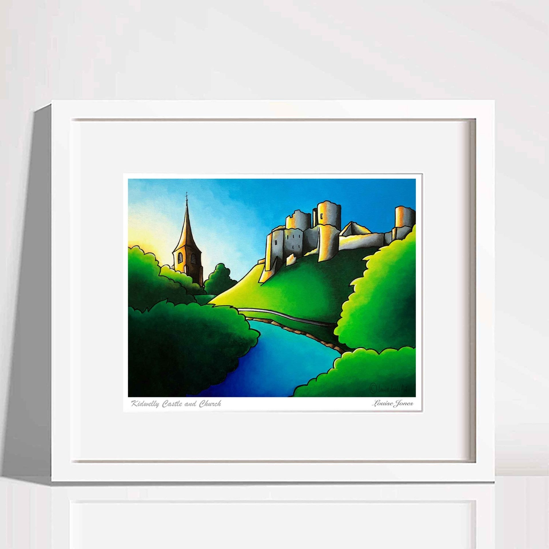 Framed Kidwelly castle art print, sitting on a plain desk leaning against a white wall.